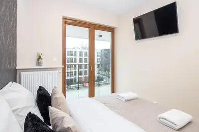 a bedroom with a bed with a flat screen tv at Angel Apartament in Kraków