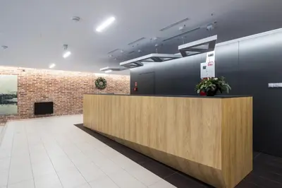 a lobby with a reception desk and a brick wall at Angel Apartament in Kraków
