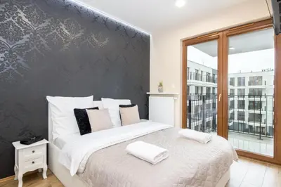 a bedroom with a large bed and a large window at Angel Apartament in Kraków