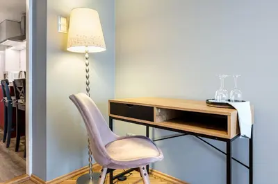 a desk with a chair next to a lamp at The Angels Apartments Krakow Old Town in Kraków
