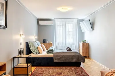 a small bedroom with a bed and a window at The Angels Apartments Krakow Old Town in Kraków
