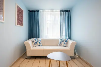a living room with a couch and a window at The Angels Apartments Krakow Old Town in Kraków
