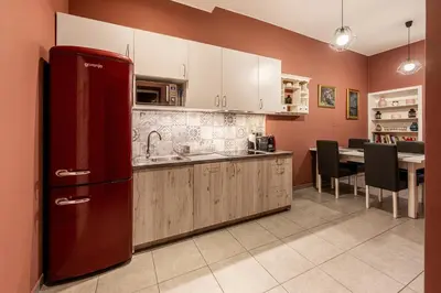 a kitchen with a red refrigerator and a table at The Angels Apartments Krakow Old Town in Kraków