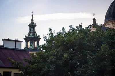 a clock tower with crosses on top of a tree at The Angels Apartments Krakow Old Town in Kraków