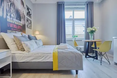 a bedroom with a bed and a table and chairs at FLORIANSKA 32 by PI Apartments in Kraków