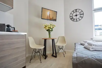 a living room with a table with a vase of flowers at FLORIANSKA 32 by PI Apartments in Kraków