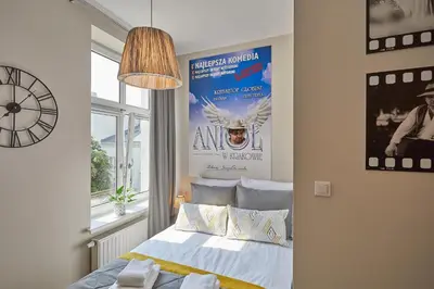 a bedroom with a bed with a poster on the wall at FLORIANSKA 32 by PI Apartments in Kraków