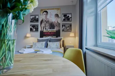 a bedroom with a bed and posters on the wall at FLORIANSKA 32 by PI Apartments in Kraków