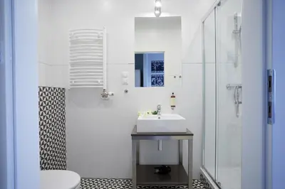 a white bathroom with a sink and a shower at FLORIANSKA 32 by PI Apartments in Kraków