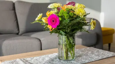 a vase filled with colorful flowers on a table at MY KRAKOW Apartments - Pianissimo in Kraków