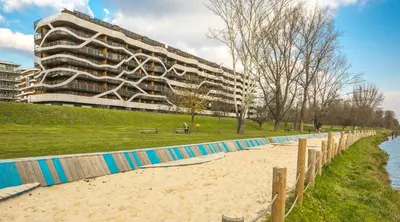 a building on the beach next to a sandy beach at MY KRAKOW Apartments - Pianissimo in Kraków
