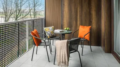 a balcony with chairs and a table and a window at MY KRAKOW Apartments - Pianissimo in Kraków