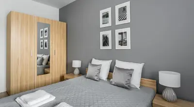 a bedroom with a bed and some pictures on the wall at MY KRAKOW Apartments - Pianissimo in Kraków
