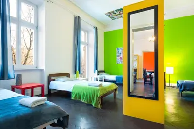 a room with two beds and a mirror at Pokoje Bagatela Stare Miasto in Kraków