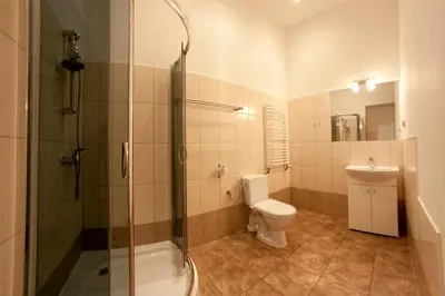 a bathroom with a shower and a toilet and a sink at Pokoje Bagatela Stare Miasto in Kraków