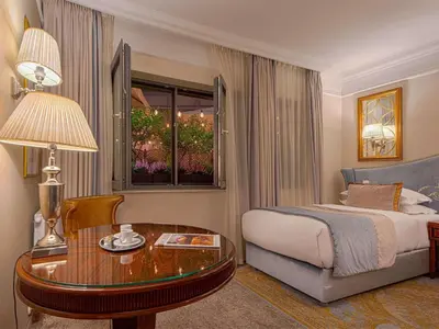 a hotel room with a bed and a desk at Bachleda Luxury Hotel Kraków - MGallery Collection in Kraków