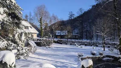 a snow covered yard with a house in the background at Agroturystyka SPA in Zelków