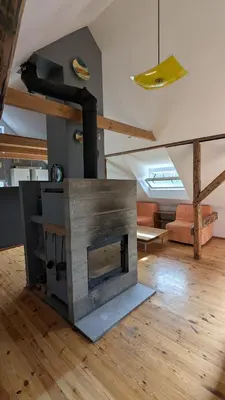 a living room with a fireplace in the middle of a room at Agroturystyka SPA in Zelków