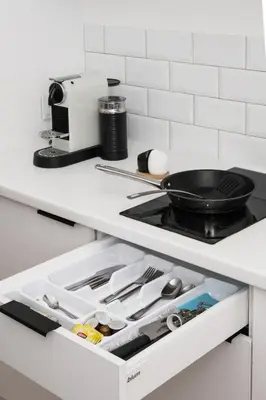 a kitchen counter with a drawer filled with utensils at Old Time Apartments in Kraków
