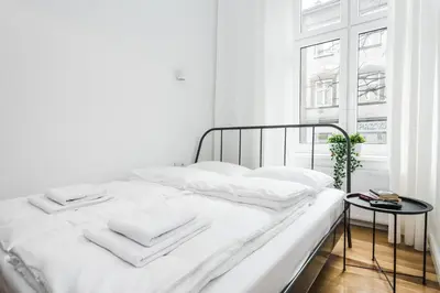 a white bed with white sheets and towels on it at Old Time Apartments in Kraków