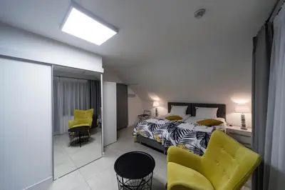 a bedroom with a bed and two yellow chairs at KP Claudia in Wieliczka