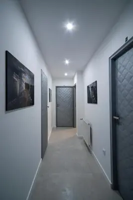 a hallway with a door and paintings on the walls at KP Claudia in Wieliczka