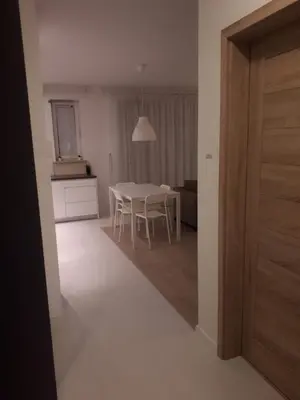 a kitchen and dining room with a white table and chairs at Wielicka Apartment 2 in Kraków