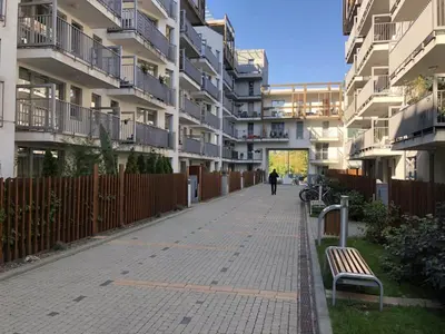 a person walking down a sidewalk next to a building at Wielicka Apartment 2 in Kraków
