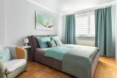 a bedroom with a bed and a chair and a window at Staymoovers - Piękna Willa w pobliżu Krakowa in Paszkówka