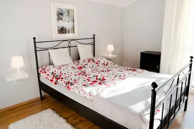 a bedroom with a bed with a red and white blanket at Staymoovers - Piękna Willa w pobliżu Krakowa in Paszkówka