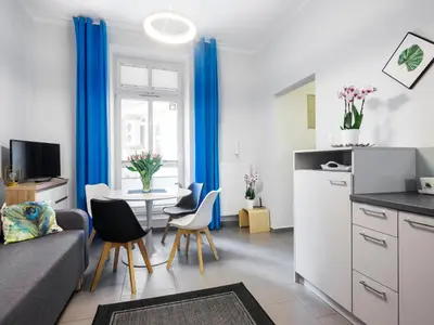 a living room with a couch and a table with chairs at CracWoW Apartment in Kraków