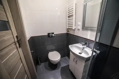 a small bathroom with a toilet and a sink at CracWoW Apartment in Kraków