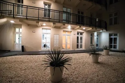 a building with two potted plants in a courtyard at CracWoW Apartment in Kraków