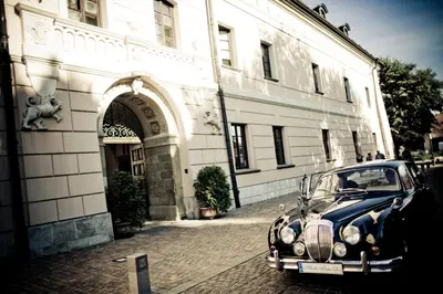 an old car parked in front of a building at Zamek Królewski w Niepołomicach in Niepołomice