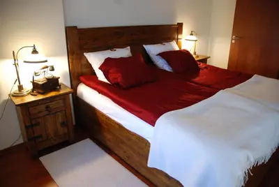 a bedroom with a large bed with red pillows at Zamek Królewski w Niepołomicach in Niepołomice
