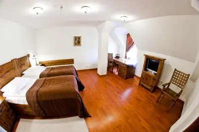 a large room with two beds and a television at Zamek Królewski w Niepołomicach in Niepołomice