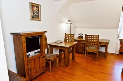 a living room with a tv and a table and chairs at Zamek Królewski w Niepołomicach in Niepołomice