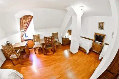 a living room with a table and chairs and a bedroom at Zamek Królewski w Niepołomicach in Niepołomice