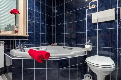 a bathroom with a red towel on a bath tub at Prywatna Rezydencja Marylin Monroe Rabka in Rabka