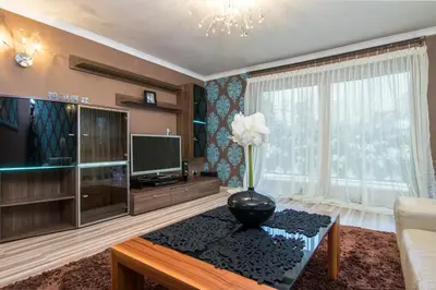 a living room with a television and a vase on a table at Prywatna Rezydencja Marylin Monroe Rabka in Rabka