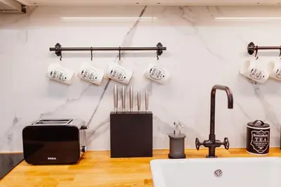 a kitchen with a counter with a toaster and a sink at Kings City - Blich Apartment in Kraków