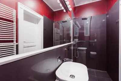 a bathroom with red walls and a sink and a toilet at Kings City - Blich Apartment in Kraków