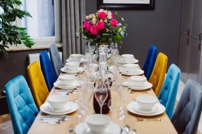 a long table with a vase of flowers on it at Kings City - Blich Apartment in Kraków