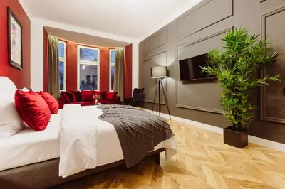 a bedroom with a large bed and a plant at Kings City - Blich Apartment in Kraków