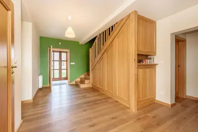 an empty living room with green walls and wooden floors at Dom w Grodzisku in Skała