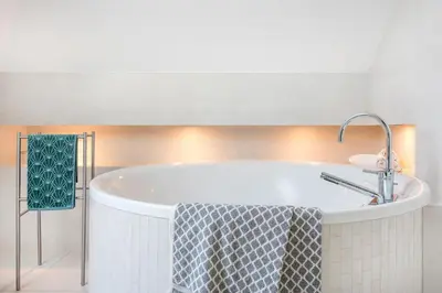 a bath tub in a bathroom with a sink at Dom w Grodzisku in Skała