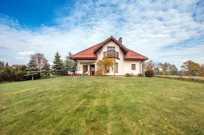 a house with a large grassy field in front of it at Dom w Grodzisku in Skała