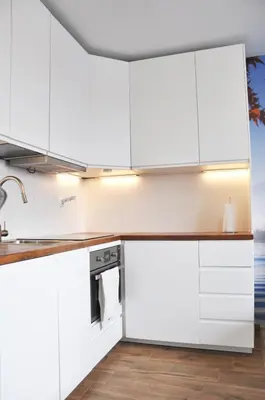 a kitchen with white cabinets and a counter top at Os. 2 pułku 26 - studio by Homeprime in Kraków