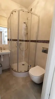 a bathroom with a shower with a toilet and a sink at Lukas Guest Rooms in Kraków