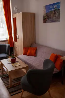 a living room with a bed and a table at Lukas Guest Rooms in Kraków